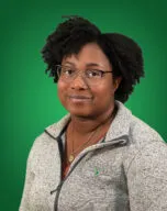 Photo of Tyler Huggins in front of a green background