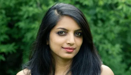 headshot of aneesha dharwadker outside against trees 