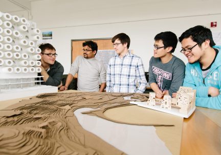 Students in design studio with a model 