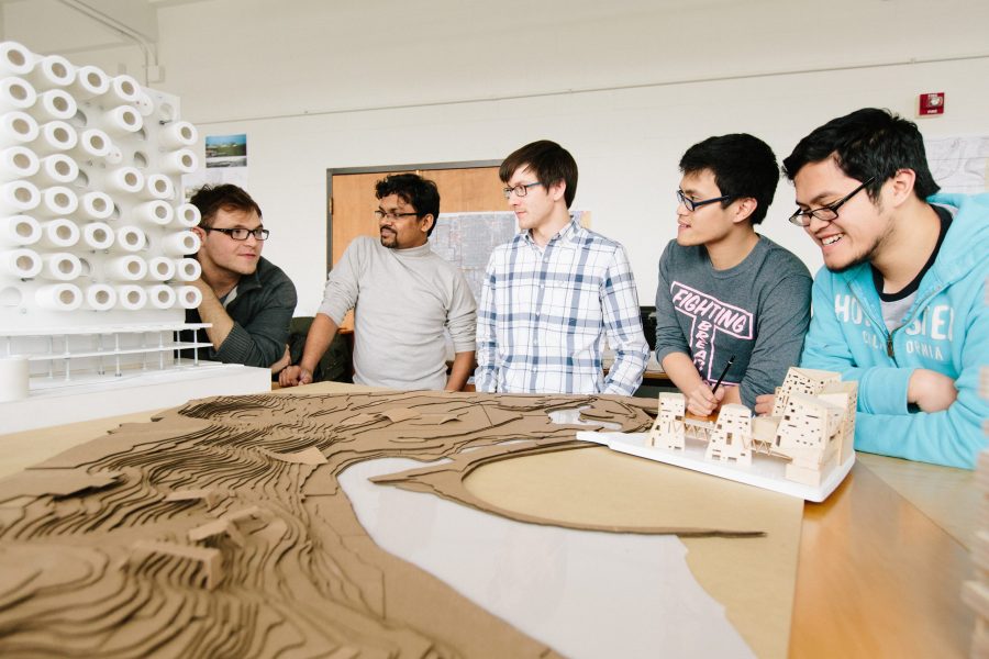 five students in studio looking at a model 
