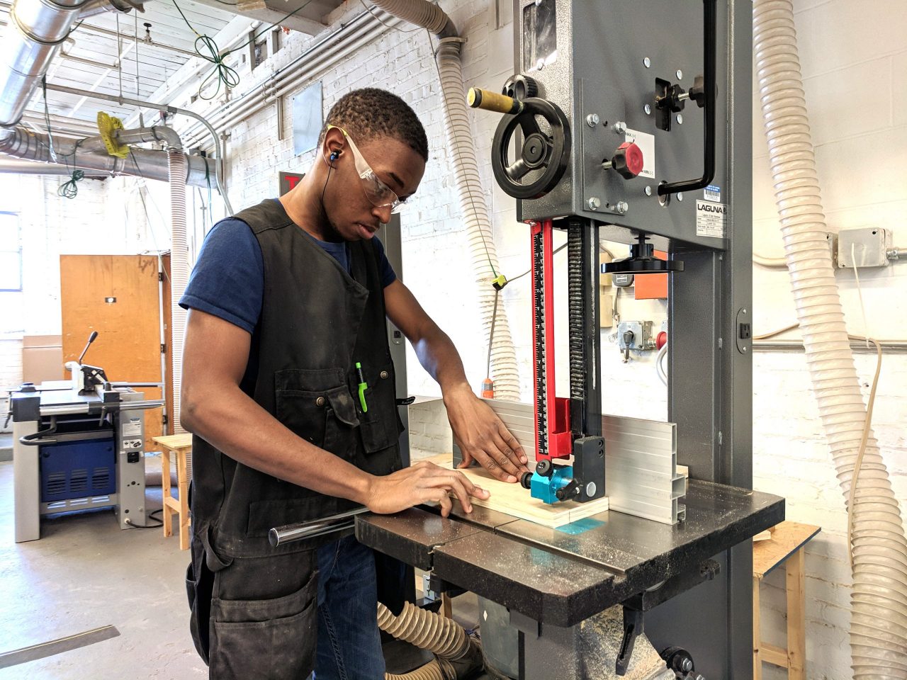 Student using a bandsaw in the woodshop 