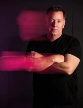 headshot of robert benson with pink shadow across the image 