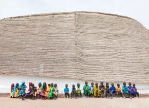 exterior image of school in senegal with students in front of building 