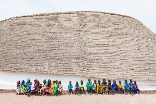 exterior image of school in senegal with students in front of building 