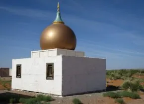 golden onion dome on a small white building 