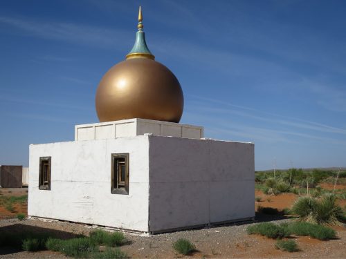 golden onion dome on a small white building 