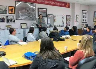 people around a conference table with Susan Sadlowski Garza standing