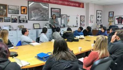 people around a conference table with Susan Sadlowski Garza standing