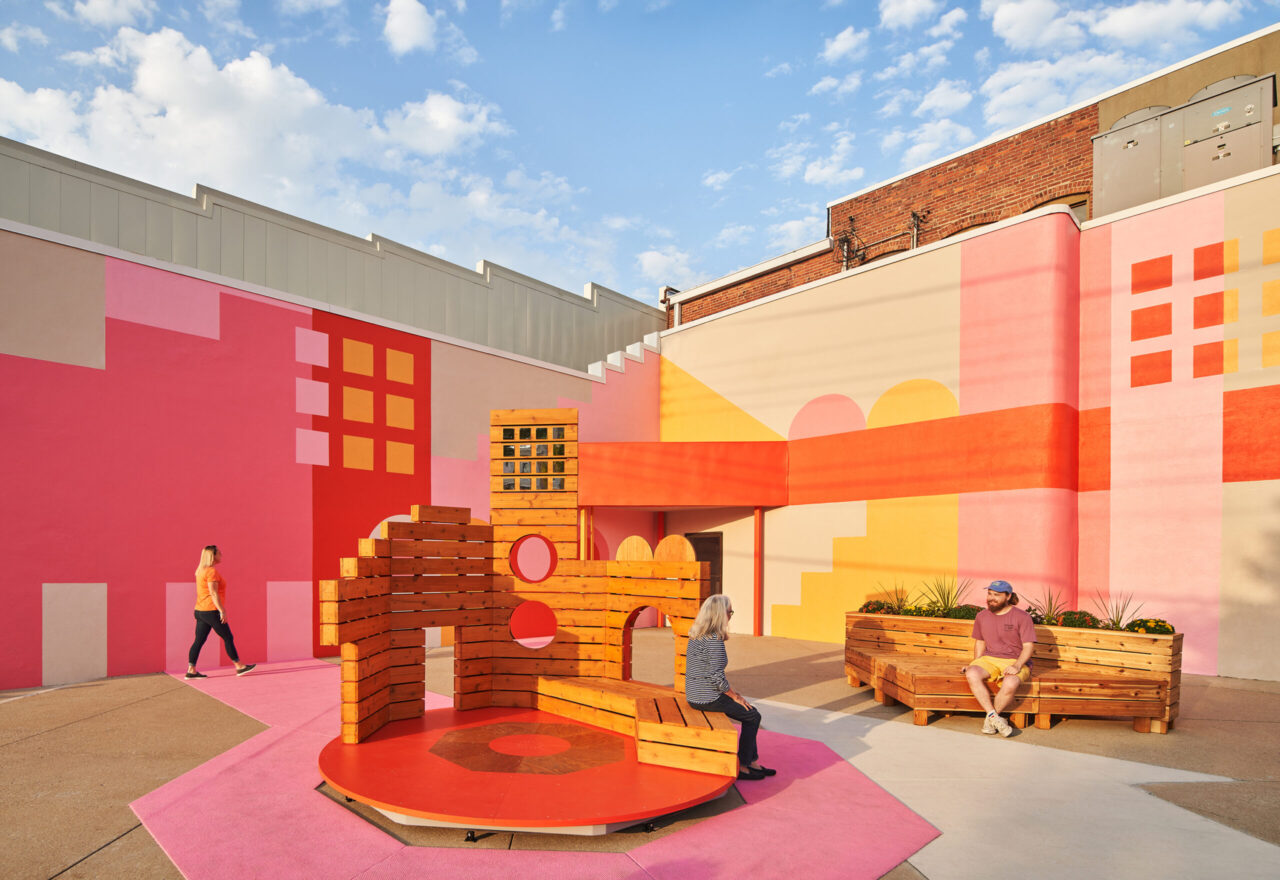 View of the carousel installation with a brightly painted background