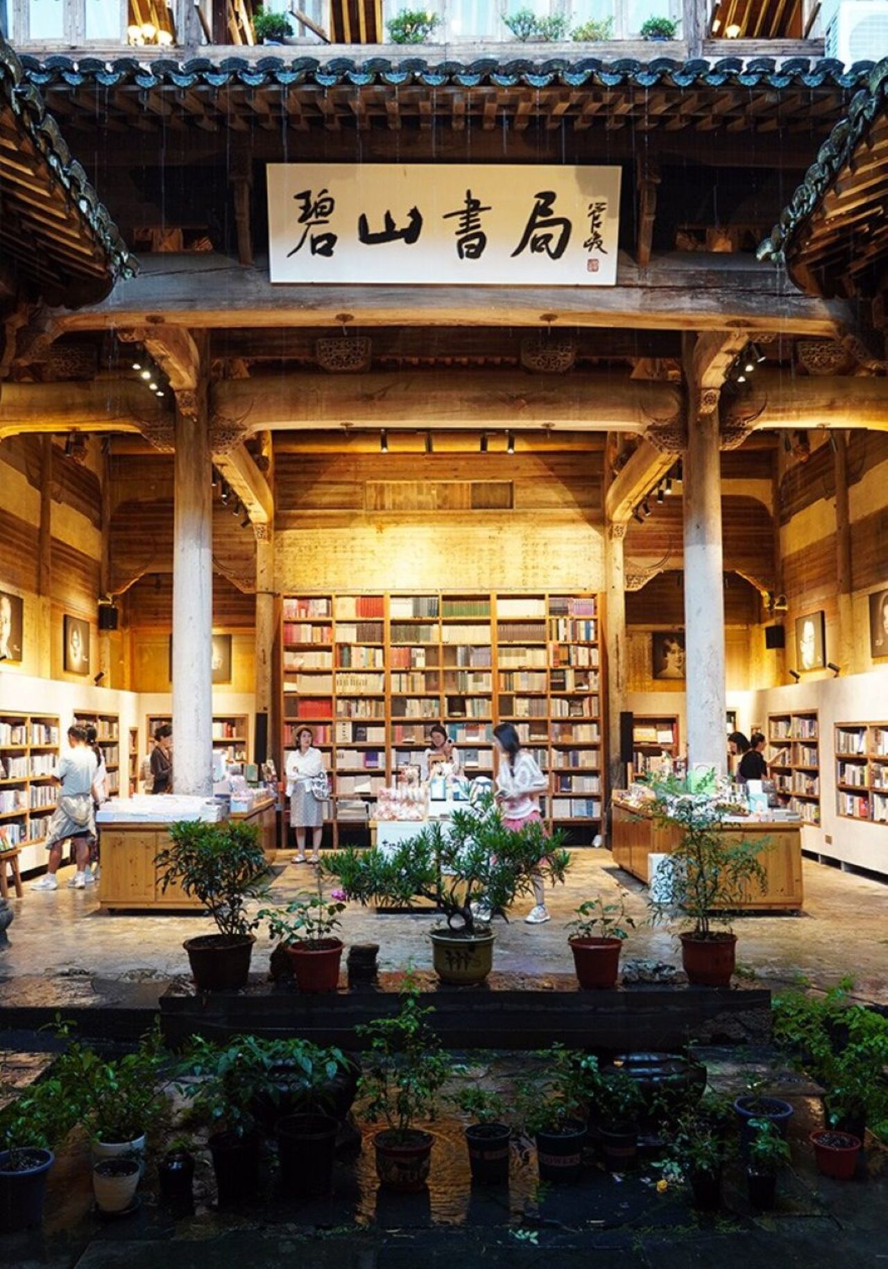 picture of open bookstore, wooden pilars and wood panel walls with bookshelves and patrons