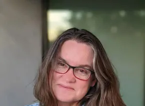 kathryn holliday wearing blue jean shirt and glasses