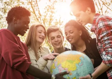 Students looking at a globe.