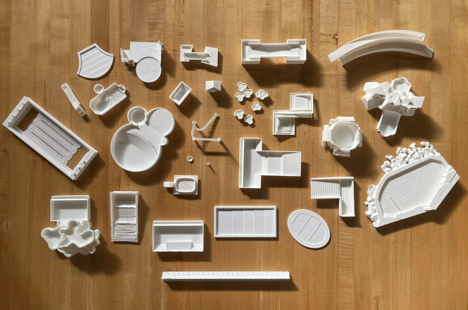 Small pieces of buildings used for the Chicago Studio.  Numerous different shapes, white color, contrasted against an oak wood background