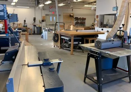 A picture of a large room with multiple woodworking benches and tools.