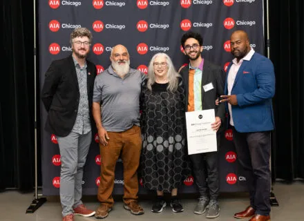 five people smiling in front of AIA Chicago step and repeat