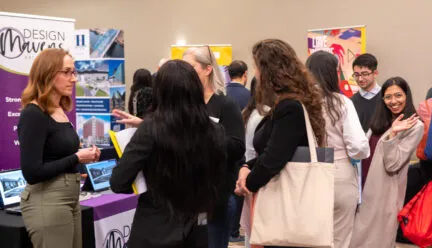 students standing together talking to a recruiter at career xpo 2024