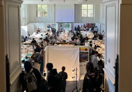 View into TBAG gallery with students gathered for an exhibit 