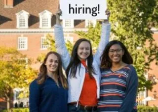 three students holding a sign that says "hiring"