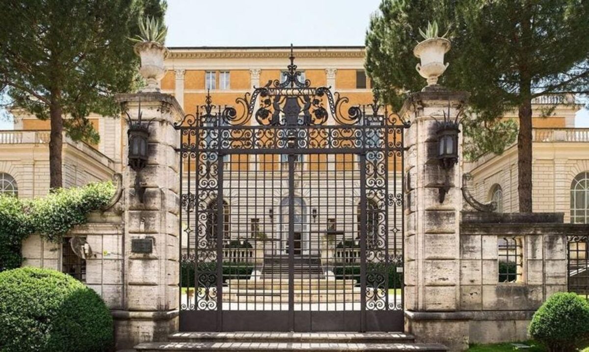 picture of gated building with lights, iron gate, yellow stucco architecture