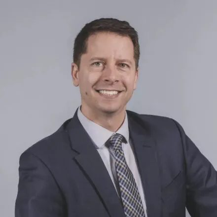 Matt streid, smiling at camera, blue blazer, purplish shirt, short cropped hair, white complexion