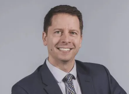 Matt streid, smiling at camera, blue blazer, purplish shirt, short cropped hair, white complexion