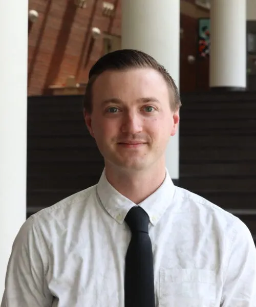 white male short hair white shirt black tie closed mouth smile looking at camera