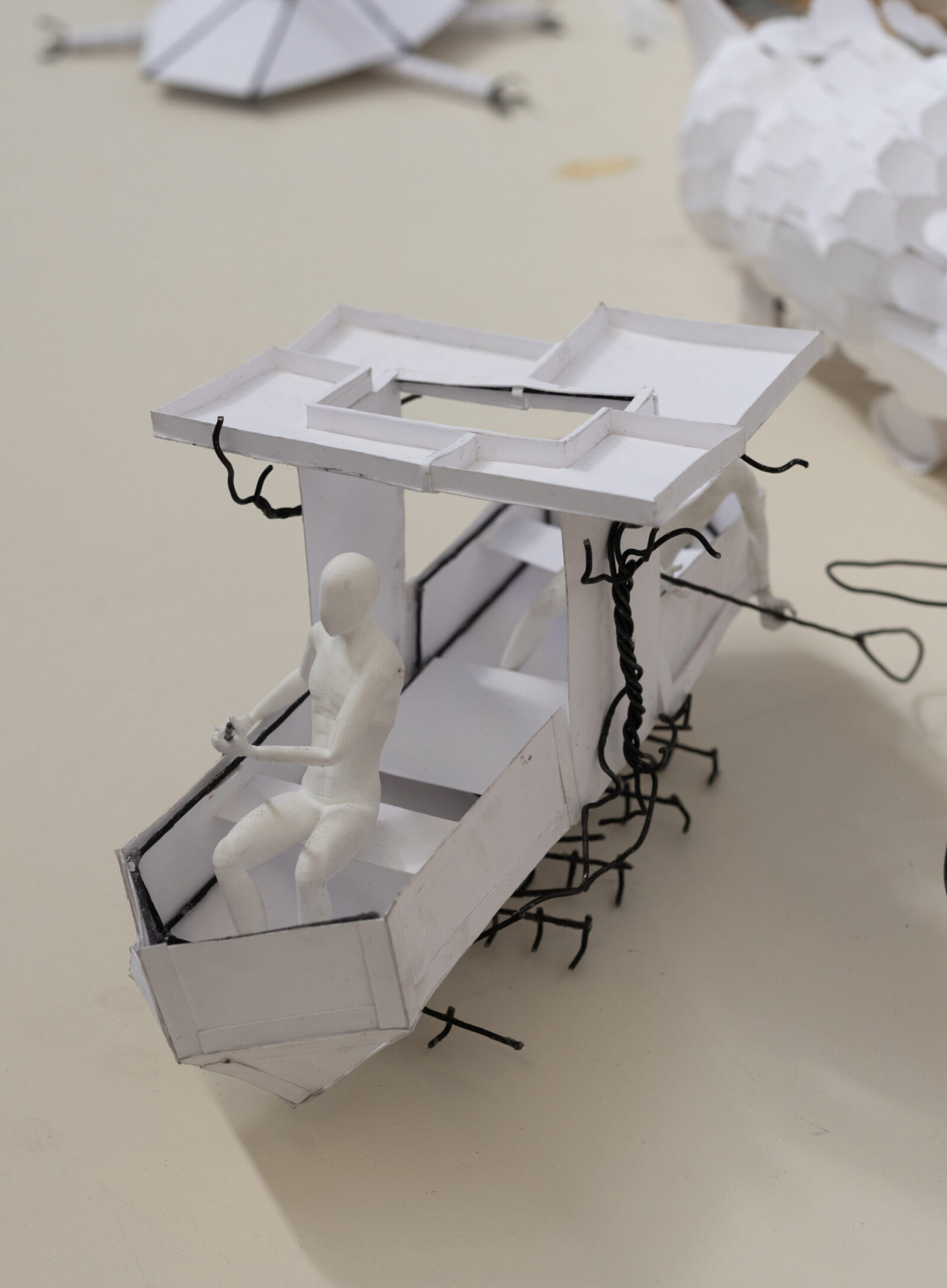 first year arch student model of a boat, white, rectangular, triangular front and square back with canopy in middle