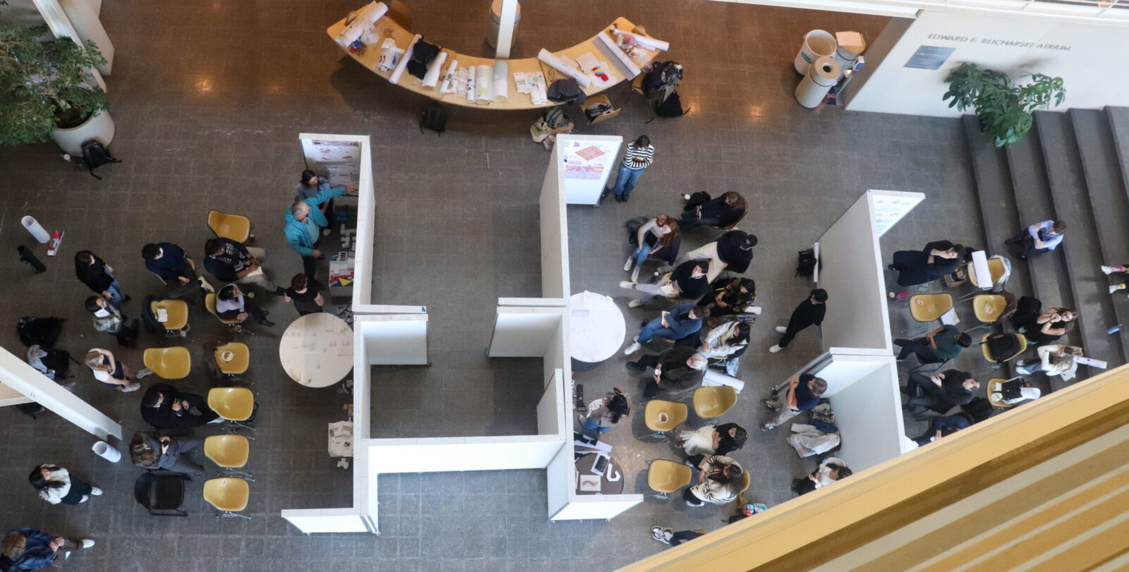 arch students in TBH atrium watching and prsenting, faculty there as well