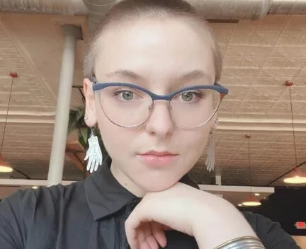 woman looking at camera glasses in ovals black shirt 