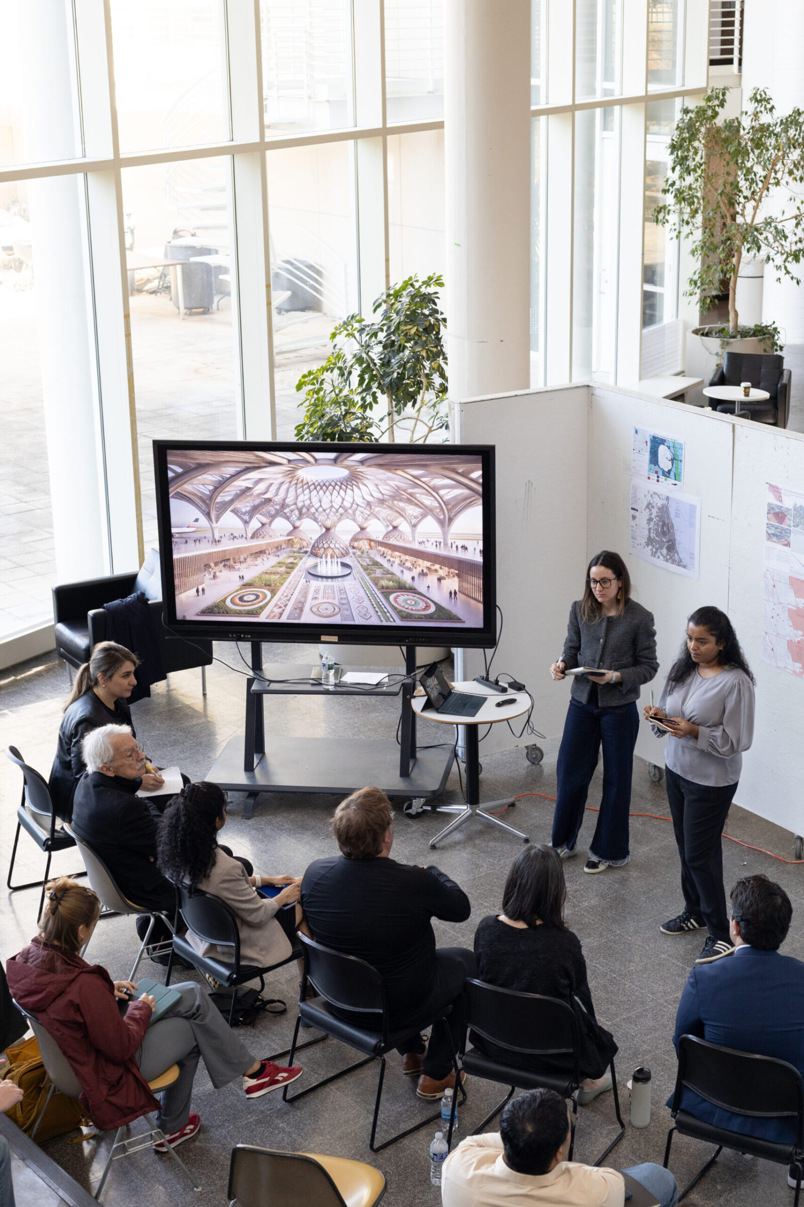 an audience in front of a tv and two people presenting