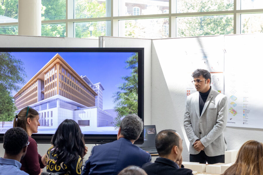 people near a tv displaying a building