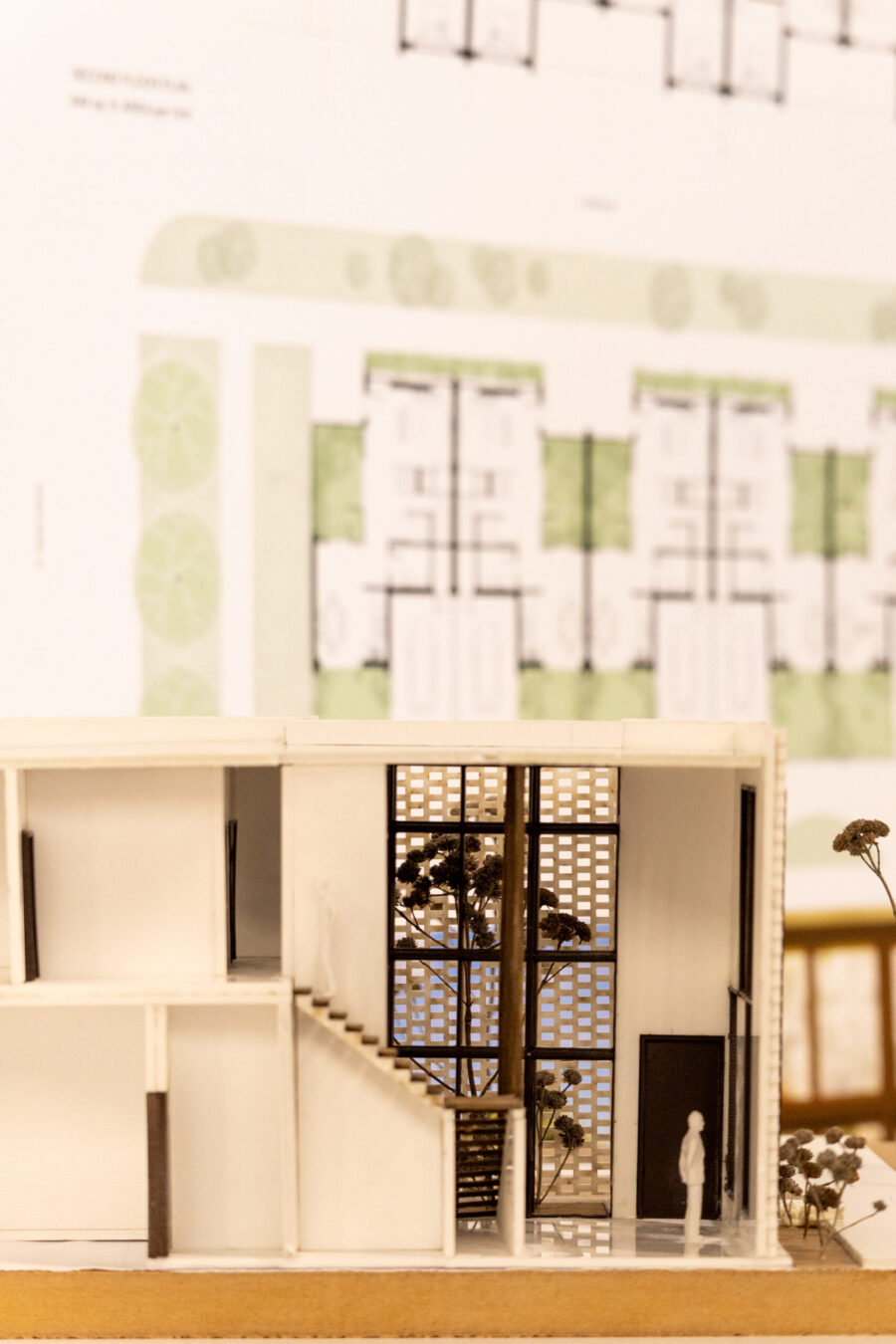 a building model with blueprints pinned up behind it