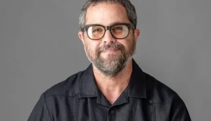 man in black shirt in photo smiling at camera beard and short hair