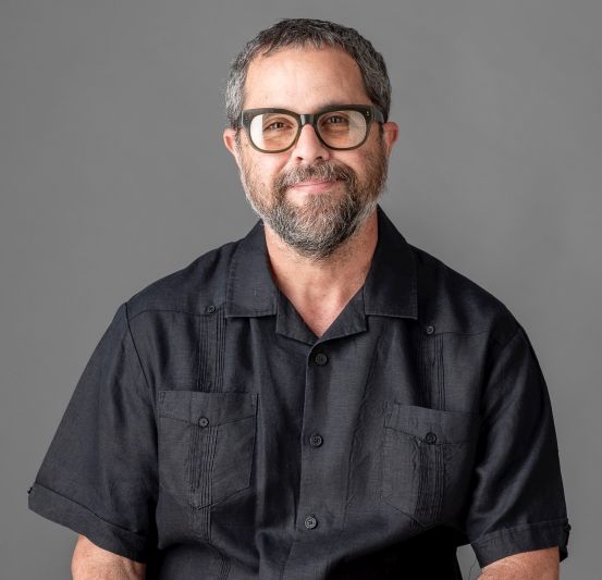 man in black shirt in photo smiling at camera beard and short hair