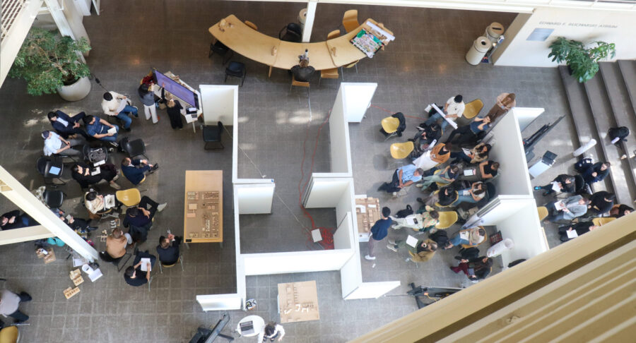 an overhead view of the atrium floor with people looking at projects