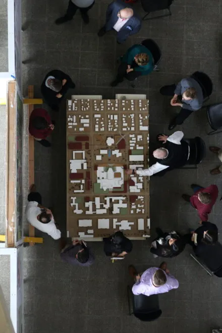 people surrounding architectural models