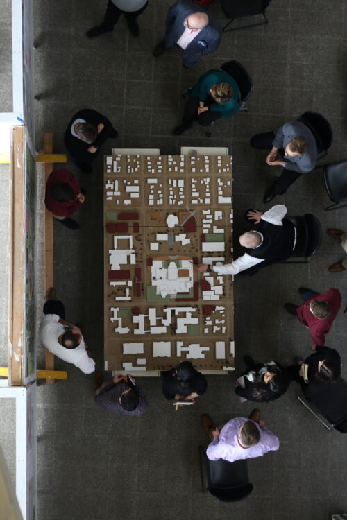 people surrounding architectural models