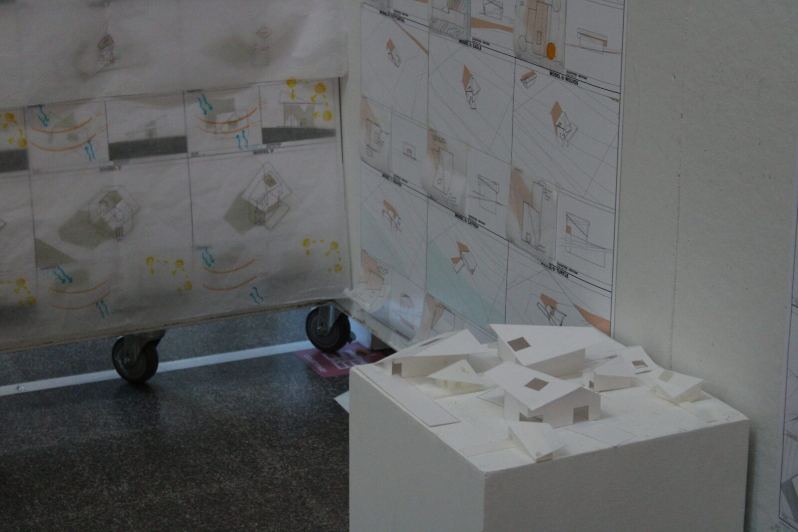 an architecture model in front of posters