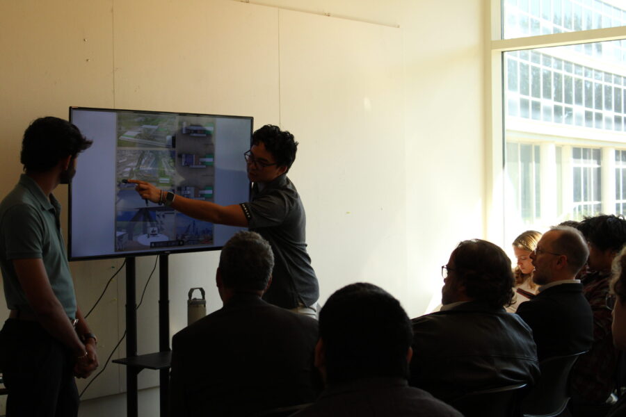 students presenting images on a tv to an audience