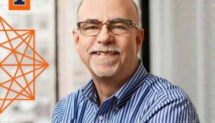 white man no hair blue and white striped shirt smiling at camera