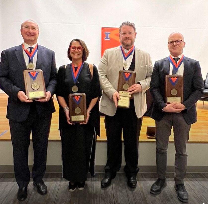 4 professors looking at the cemera and smiling