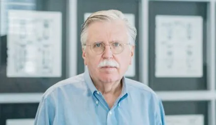 white man looking at camera with blue button up shirt