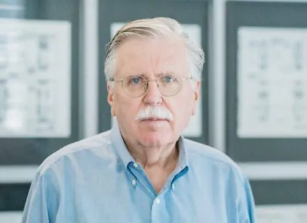 white man looking at camera with blue button up shirt