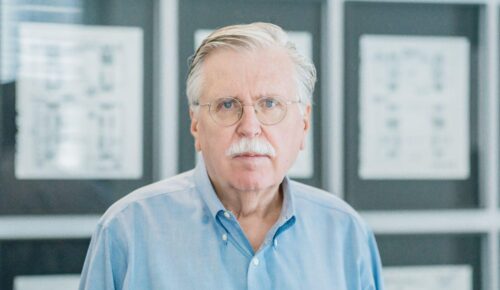 white man looking at camera with blue button up shirt