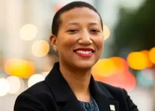 African American woman in black jacket and blue top