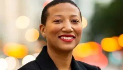 African American woman in black jacket and blue top