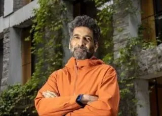 Male with Black and Grey hair in orange jacket