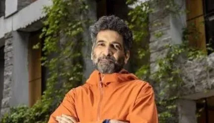 Male with Black and Grey hair in orange jacket