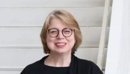 picture of blonde with black outfit and round glasses