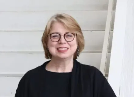 Caucasian lady with Blond colored hair in black top 